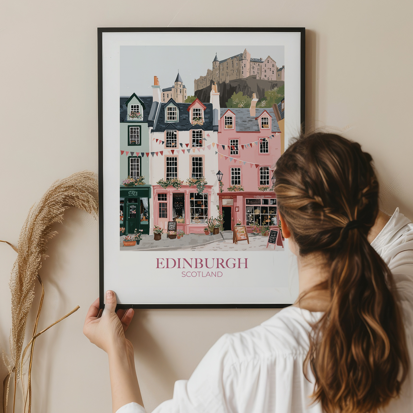 Person holding a framed print of Edinburgh, Scotland with a scenic view of colorful buildings.