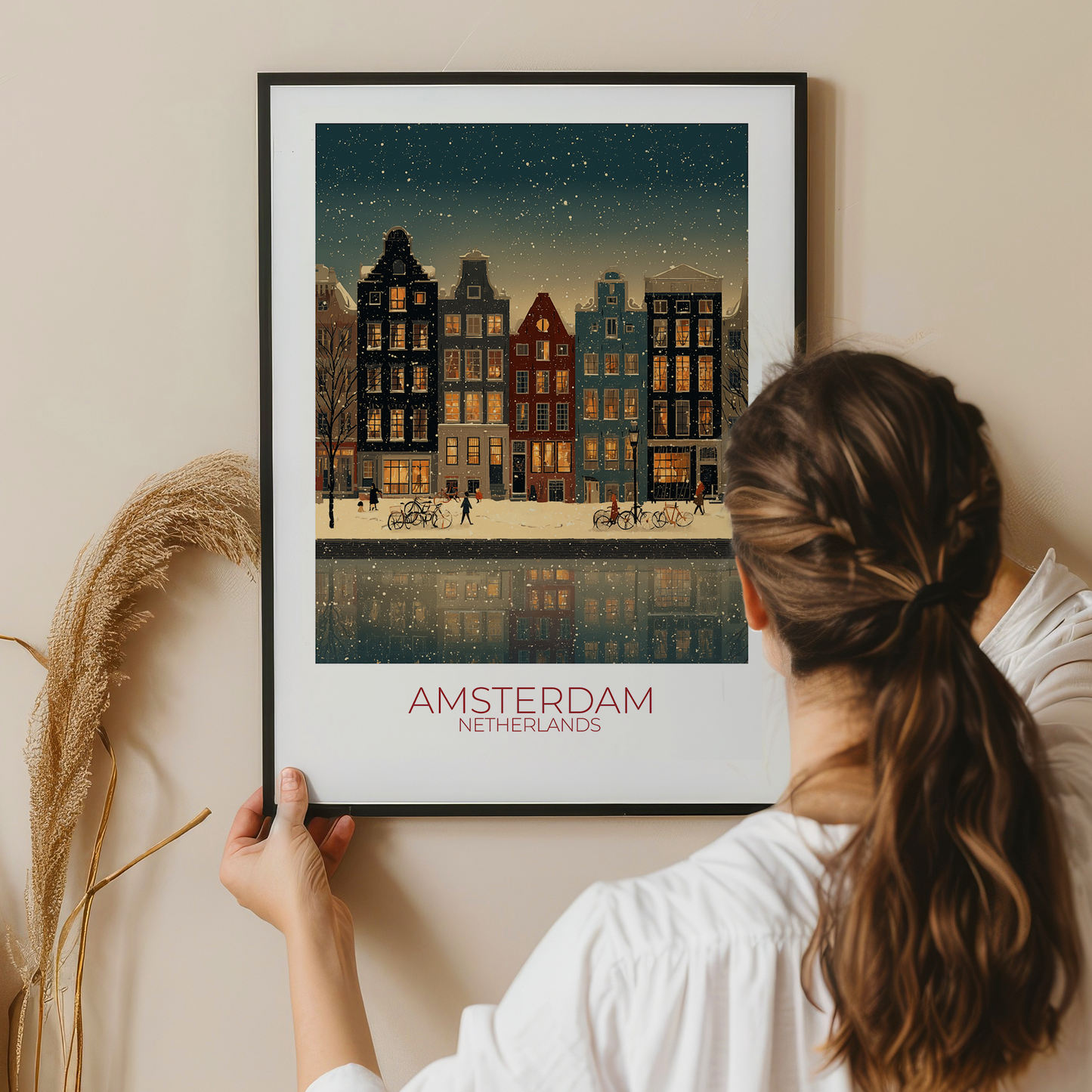 Person holding a framed print of Amsterdam, Netherlands with a cityscape and canal.