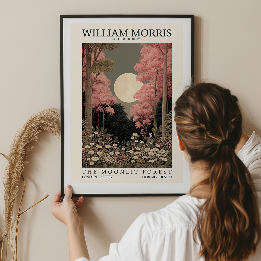Woman holding a framed artwork titled 'The Moonlit Forest' by William Morris.