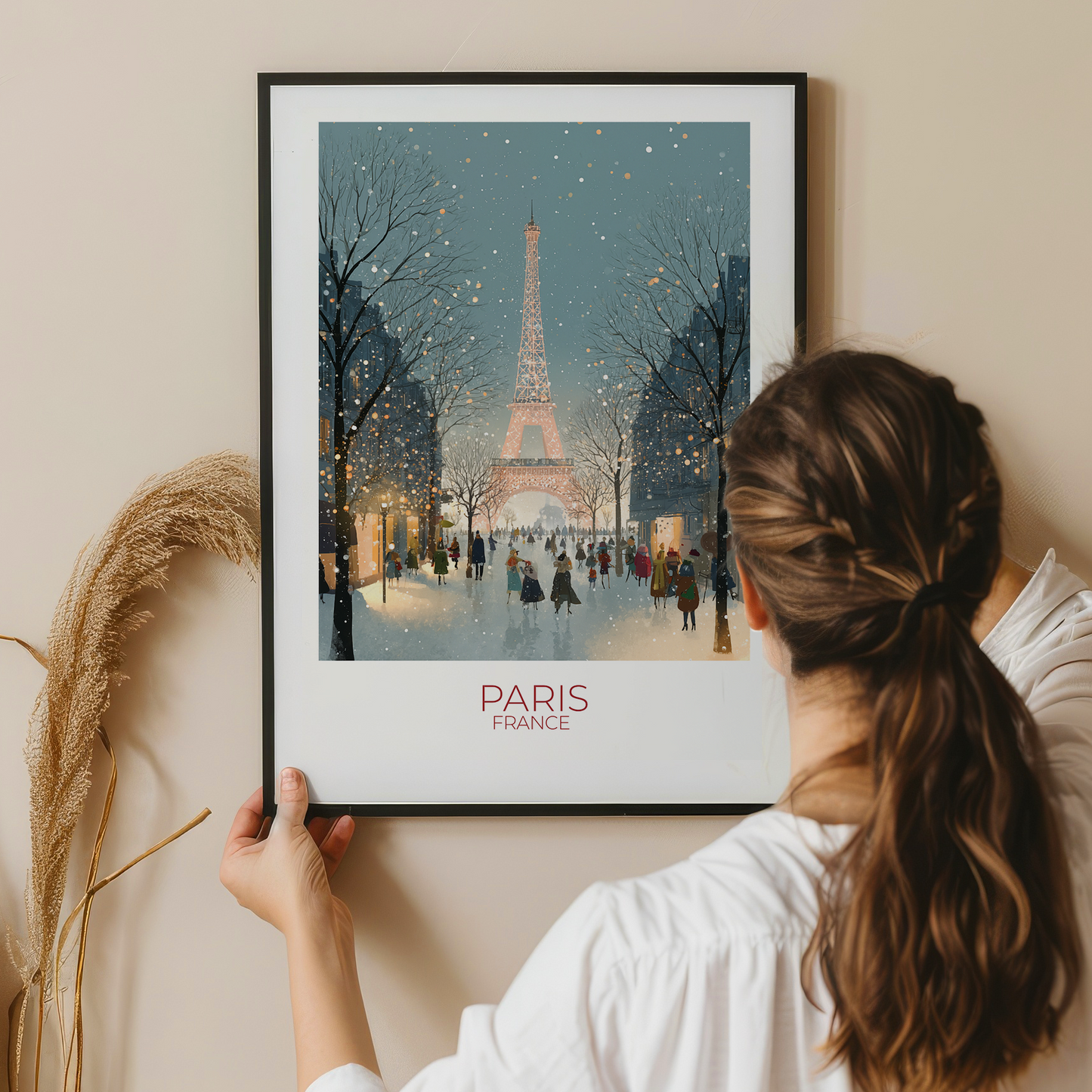 Person holding a framed print of the Eiffel Tower in Paris, France.