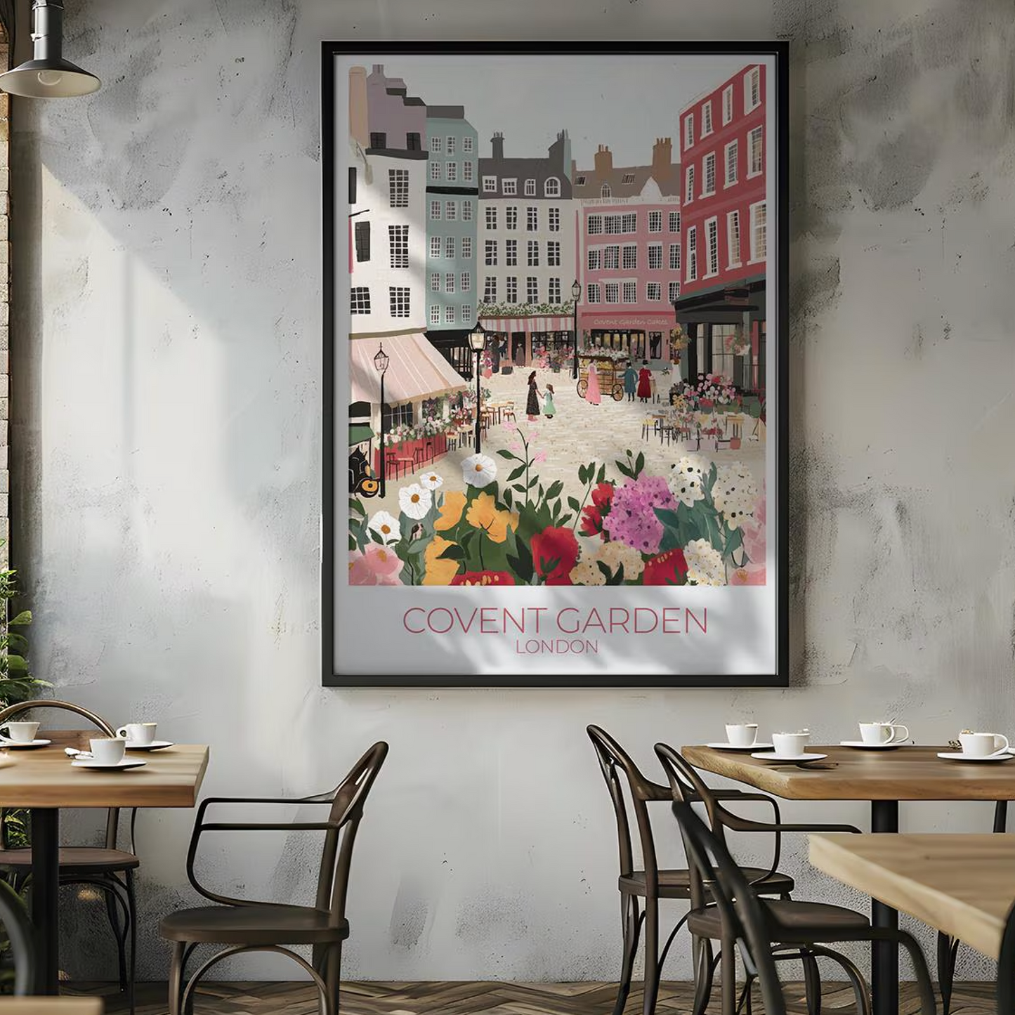 Framed illustration of Covent Garden, London, showing a vibrant market scene with colorful buildings, flower stalls, and people. The print hangs above a wooden dining table set with kitchenware, with white subway tiles and shelves in the background. Text on the print reads 'COVENT GARDEN LONDON'.