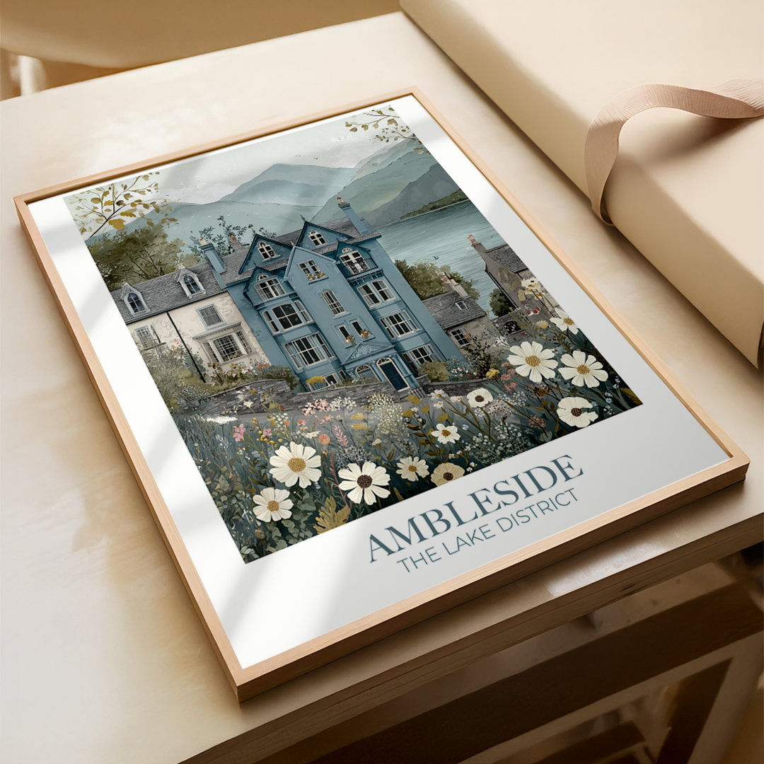 Framed artwork of a house with flowers and 'Ambleside' text on a light surface
