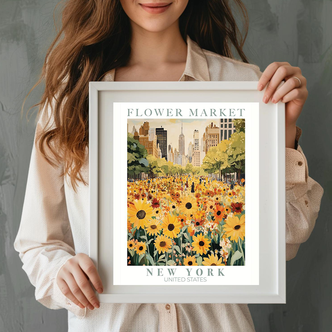 Person holding a framed print of a flower market in New York with a cityscape background.
