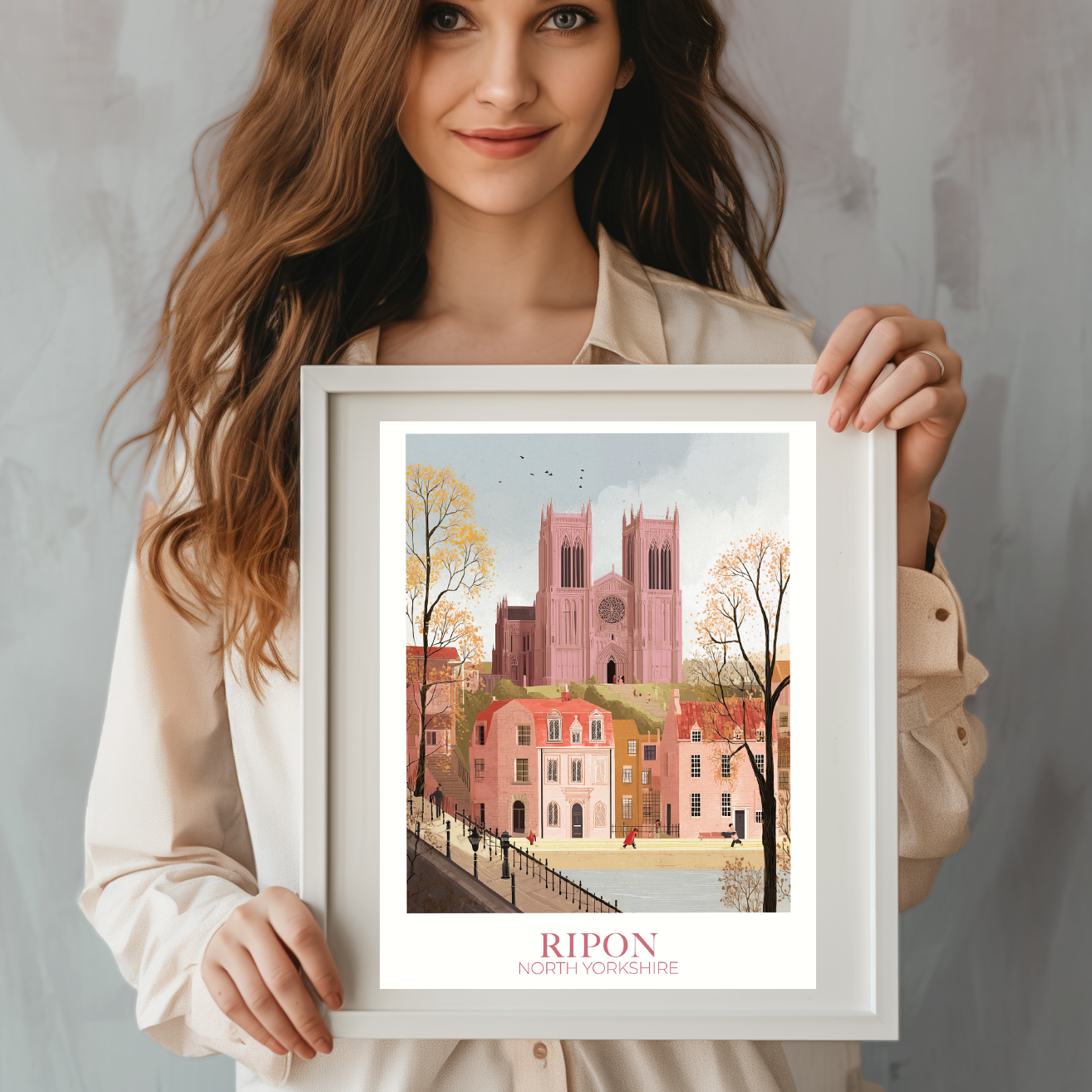Woman holding a framed artwork of a cityscape with 'Ripon' text on a plain background