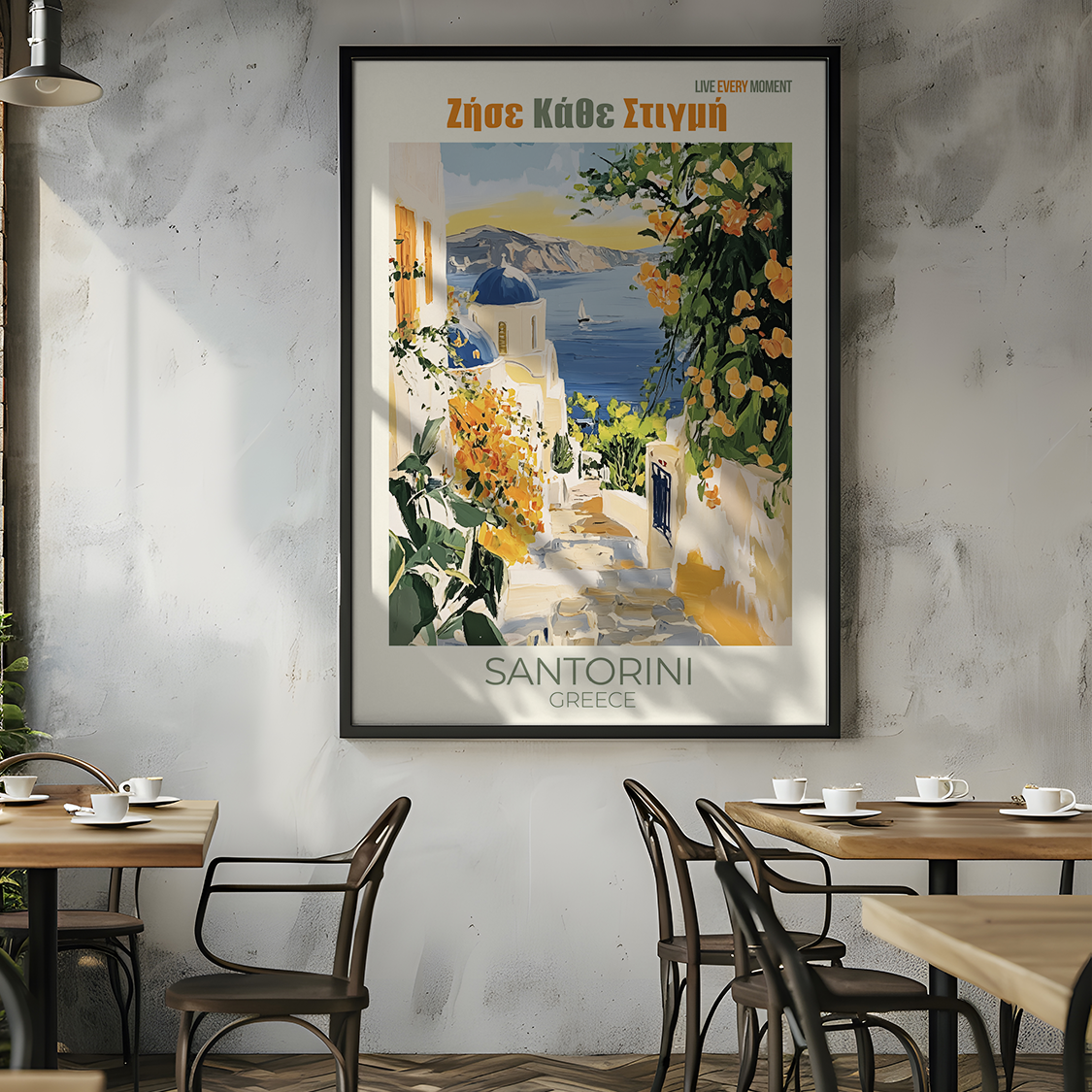 Framed travel poster of Santorini on a wall in a modern cafe.