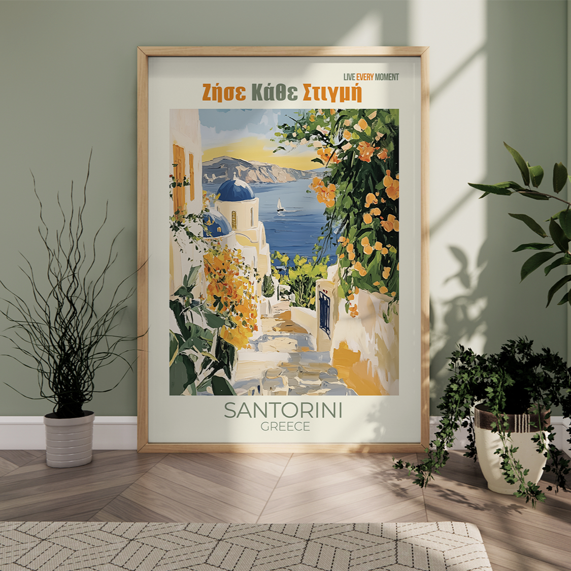 Framed Santorini travel poster on a wall with plants around