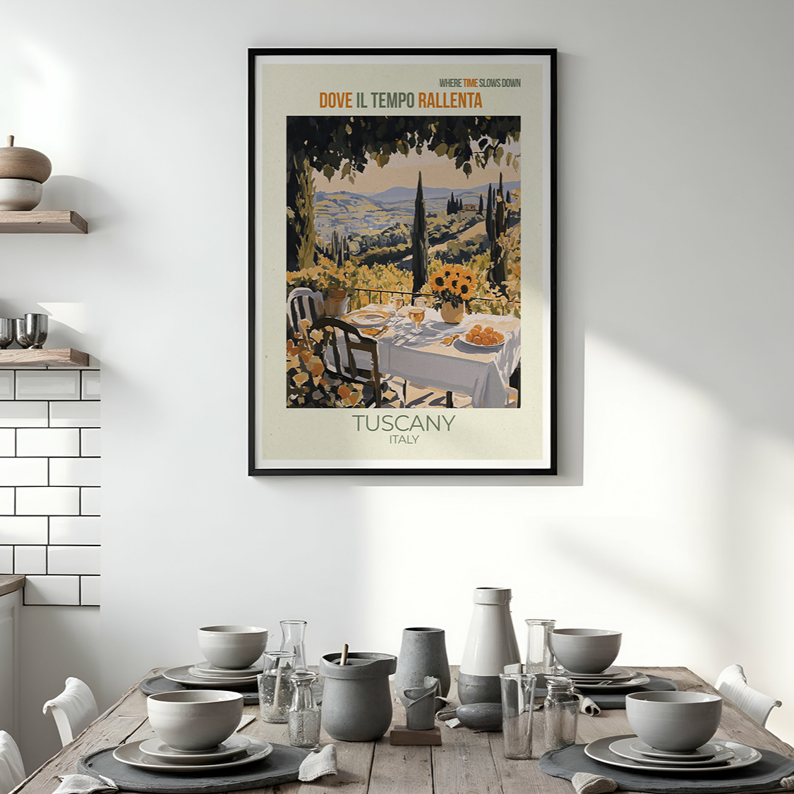 Dining room with a framed poster of Tuscany on the wall above a table set for dinner.