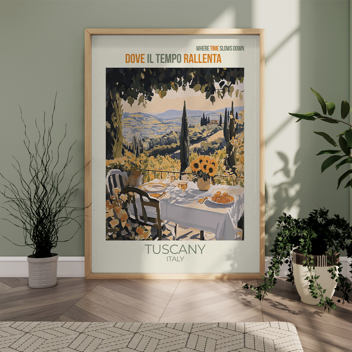 Framed poster of Tuscany, Italy with a scenic view and table setting, placed on a wooden floor.