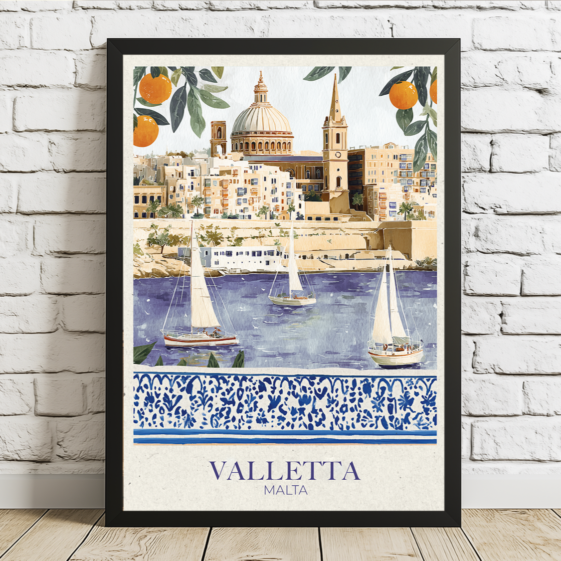 Framed artwork of Valletta, Malta with sailboats and a decorative border on a white brick wall.