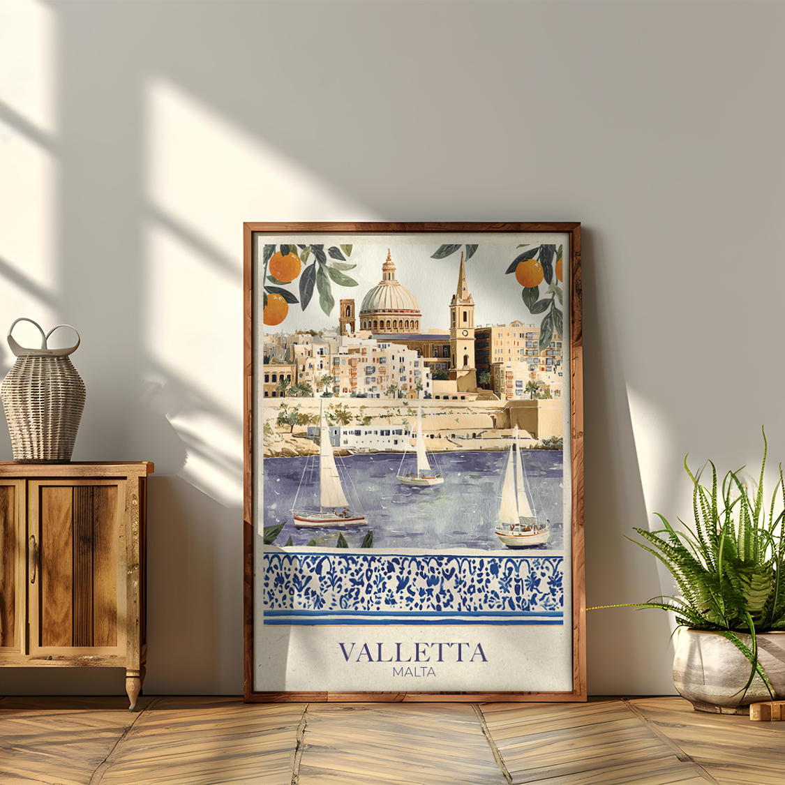 Framed artwork of Valletta on a wall with wooden cabinet and plants