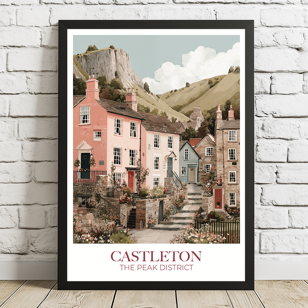 Framed artwork of a picturesque village scene with text 'Castleton, The Peak District' on a white brick wall.