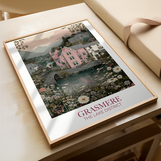 Framed artwork of a scenic view with 'Grasmere The Lake District' text on a wooden surface.