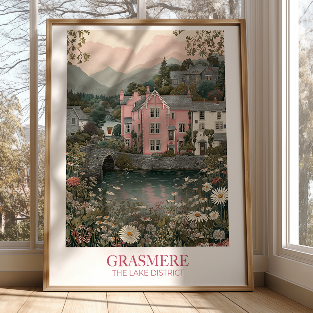 Framed artwork of a scenic village with a pink house, lake, and bridge, titled 'Grasmere The Lake District'.
