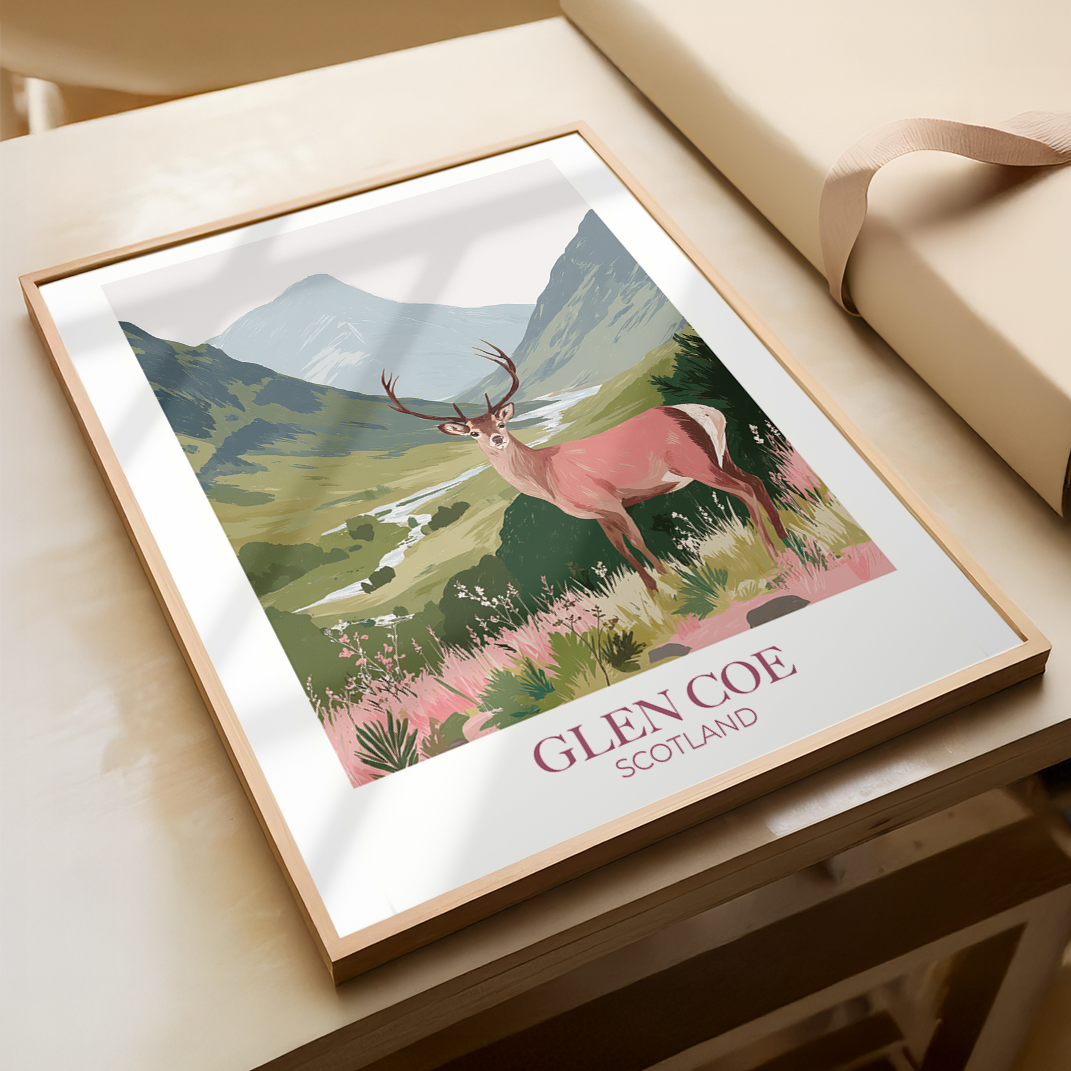Framed artwork of a deer in Glencoe, Scotland on a wooden surface.