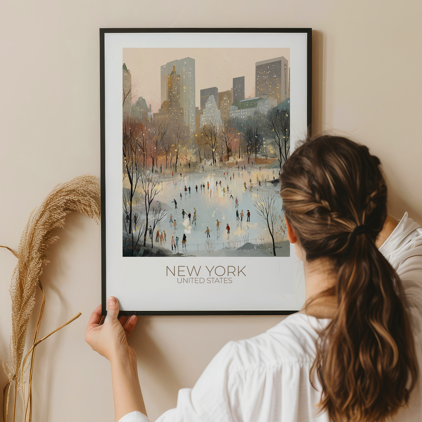 Person holding a framed print of New York City with a lake and people.