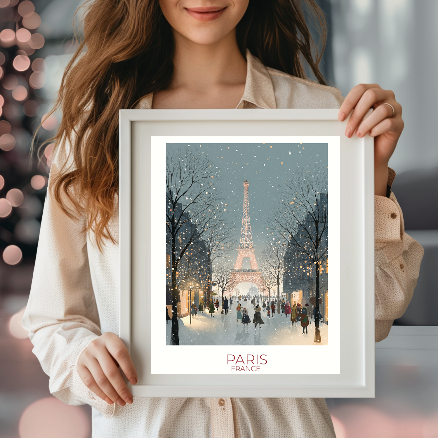 Person holding a framed picture of the Eiffel Tower in Paris with festive lights in the background.