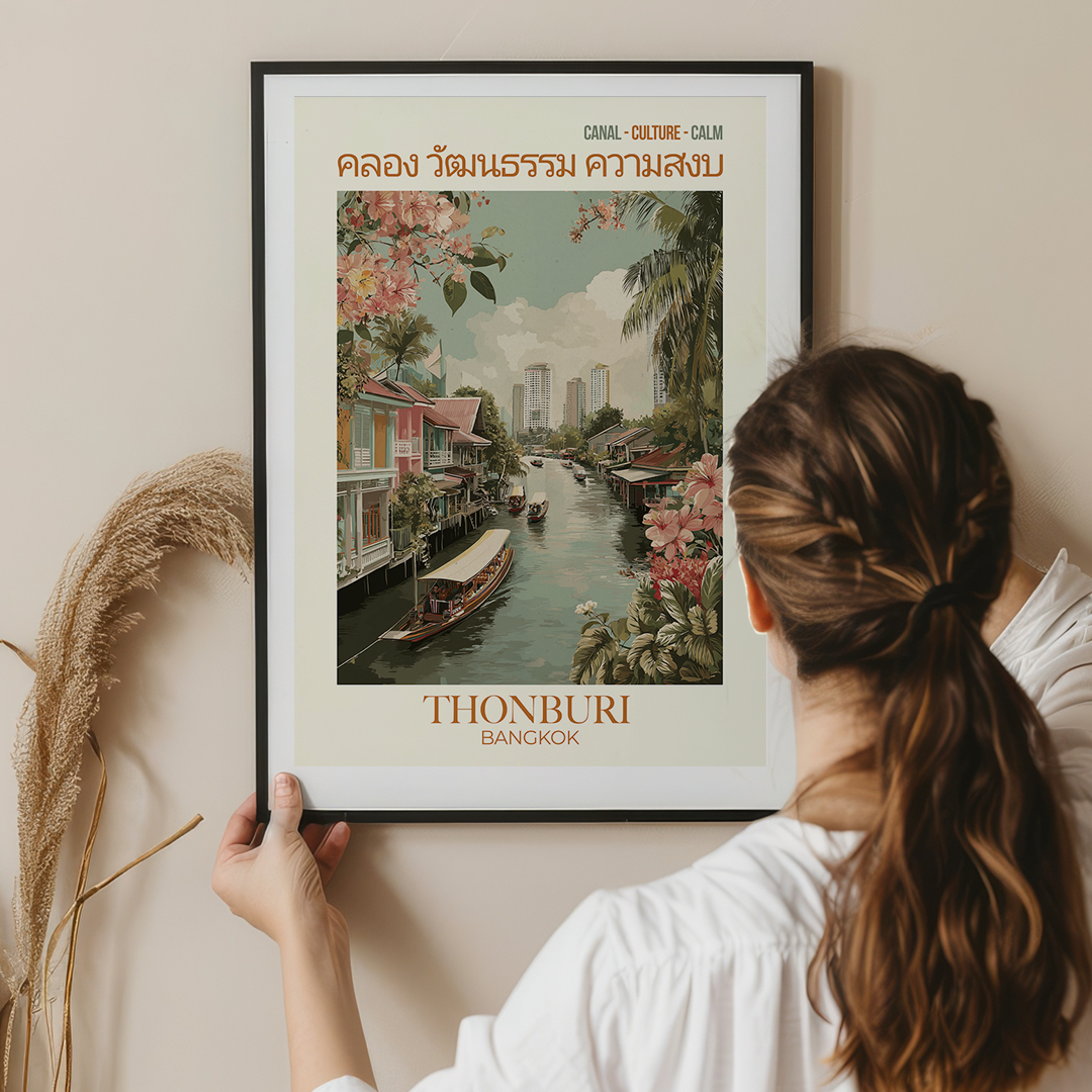 Person holding a framed poster of Thonburi Bangkok with a scenic view of a canal.
