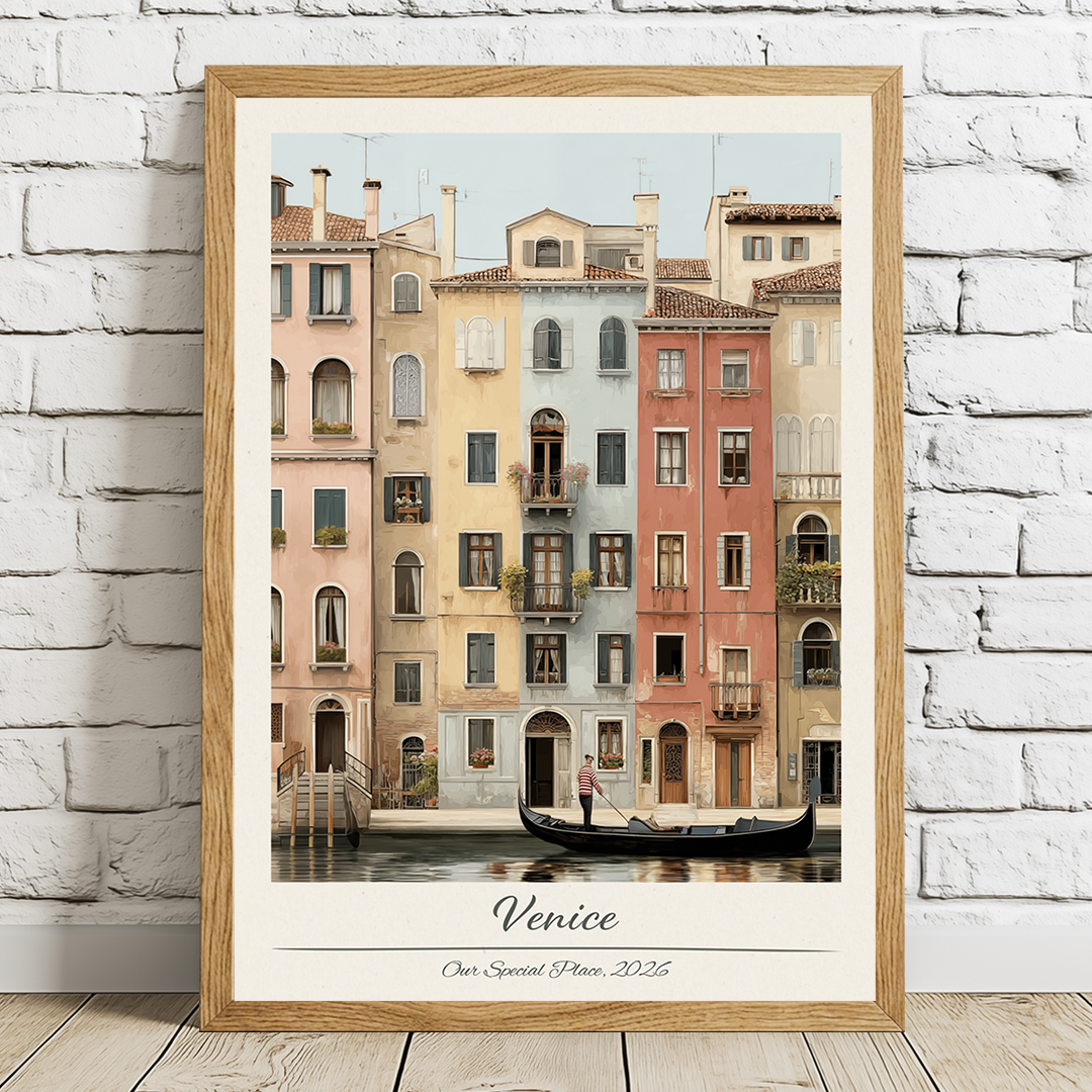 Framed artwork of a canal scene with buildings in Venice, displayed on a white brick wall.