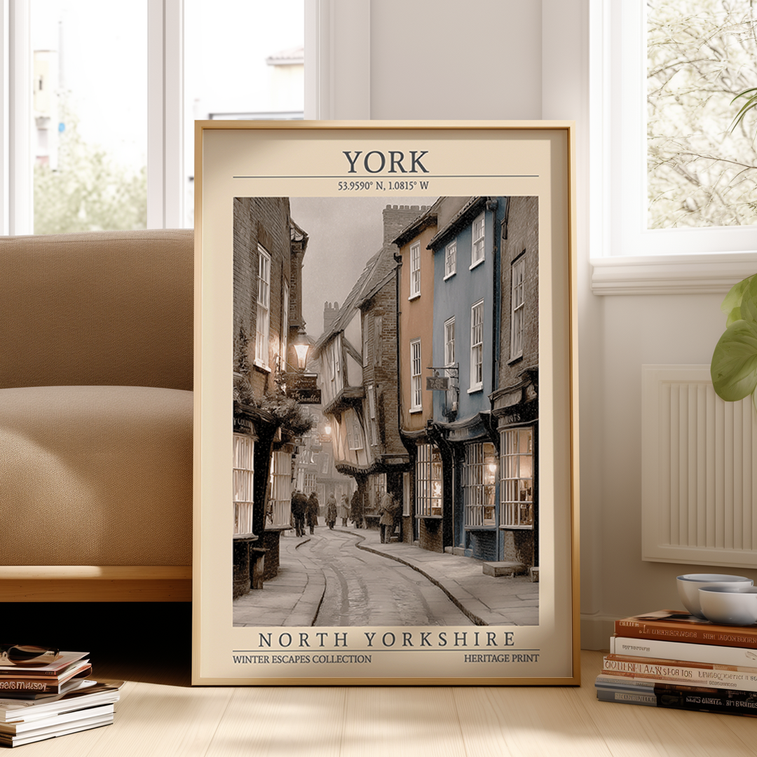Framed poster of a street scene in York, North Yorkshire, on a wall in a room with a couch and books.