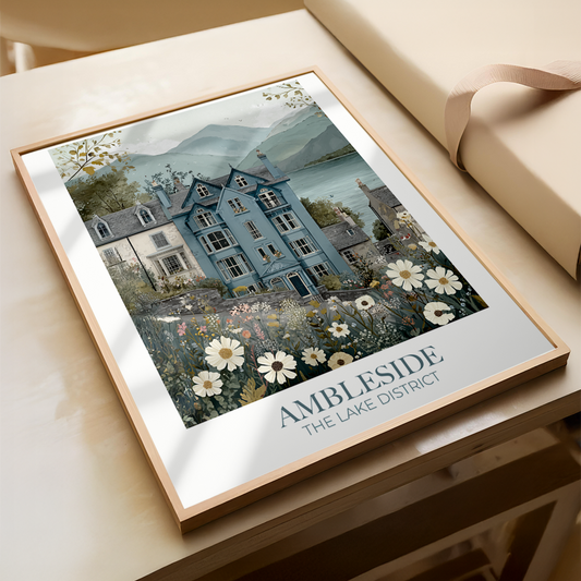 Framed artwork of a house with flowers and 'Ambleside' text on a light surface