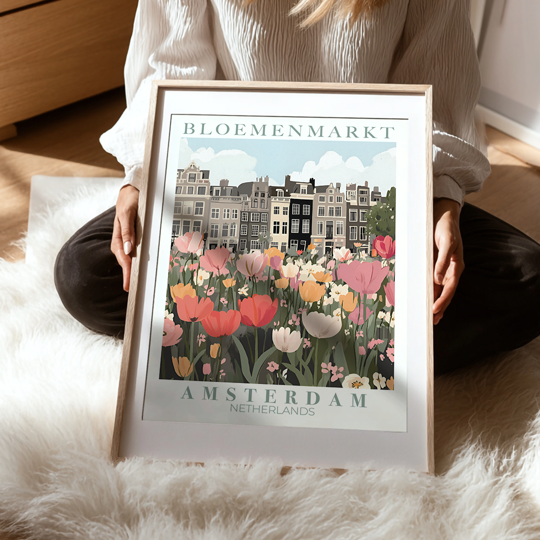 Person holding a framed print of Bloemenmarkt, Amsterdam with tulips and buildings.