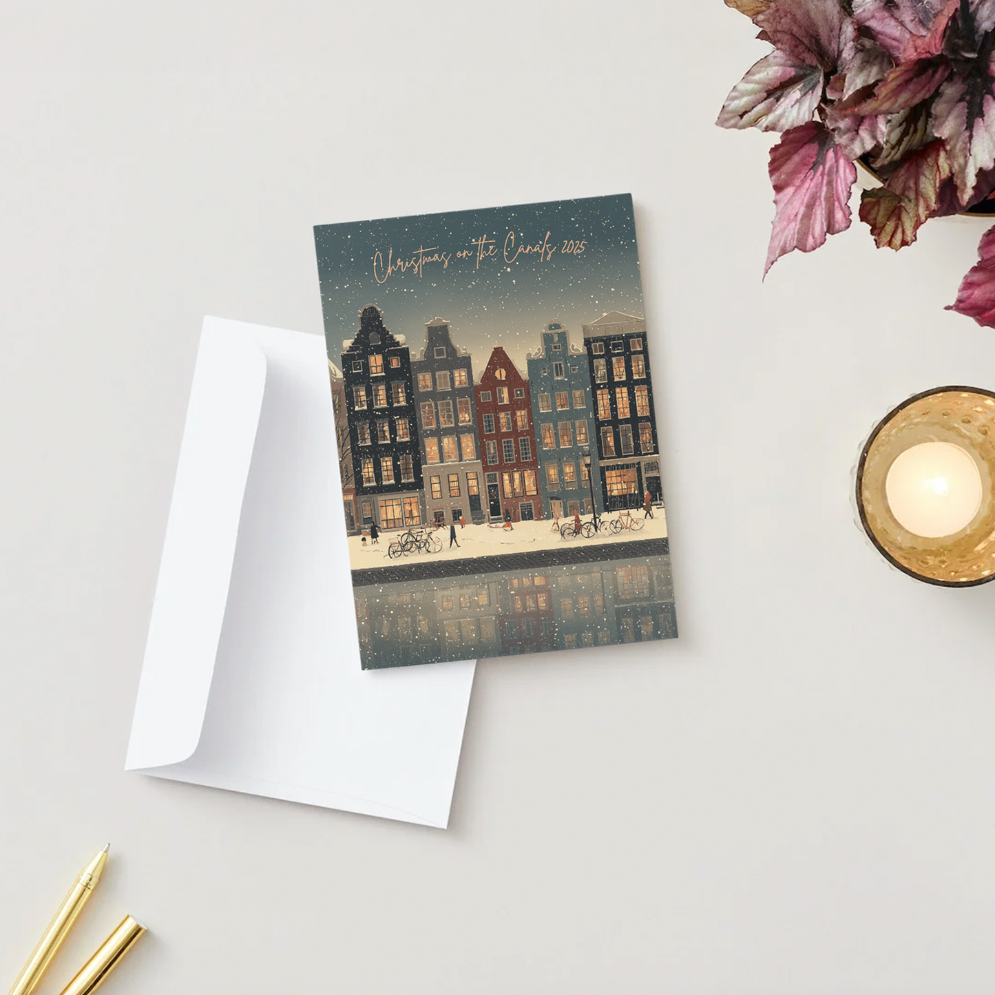 Greeting card with an Amsterdam cityscape design on a light surface with a candle and flowers.