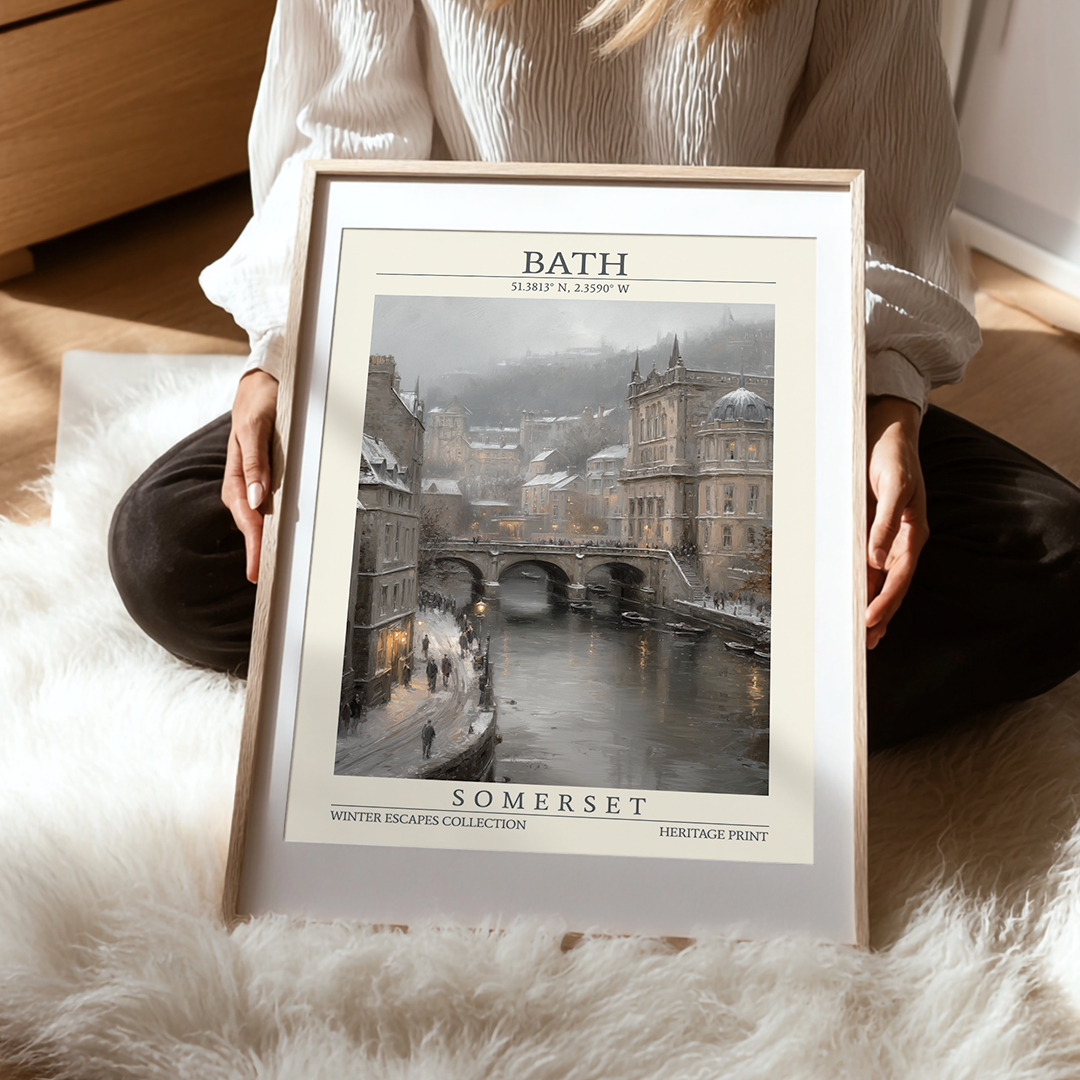 Person holding a framed print of Bath, Somerset with a snowy scene.