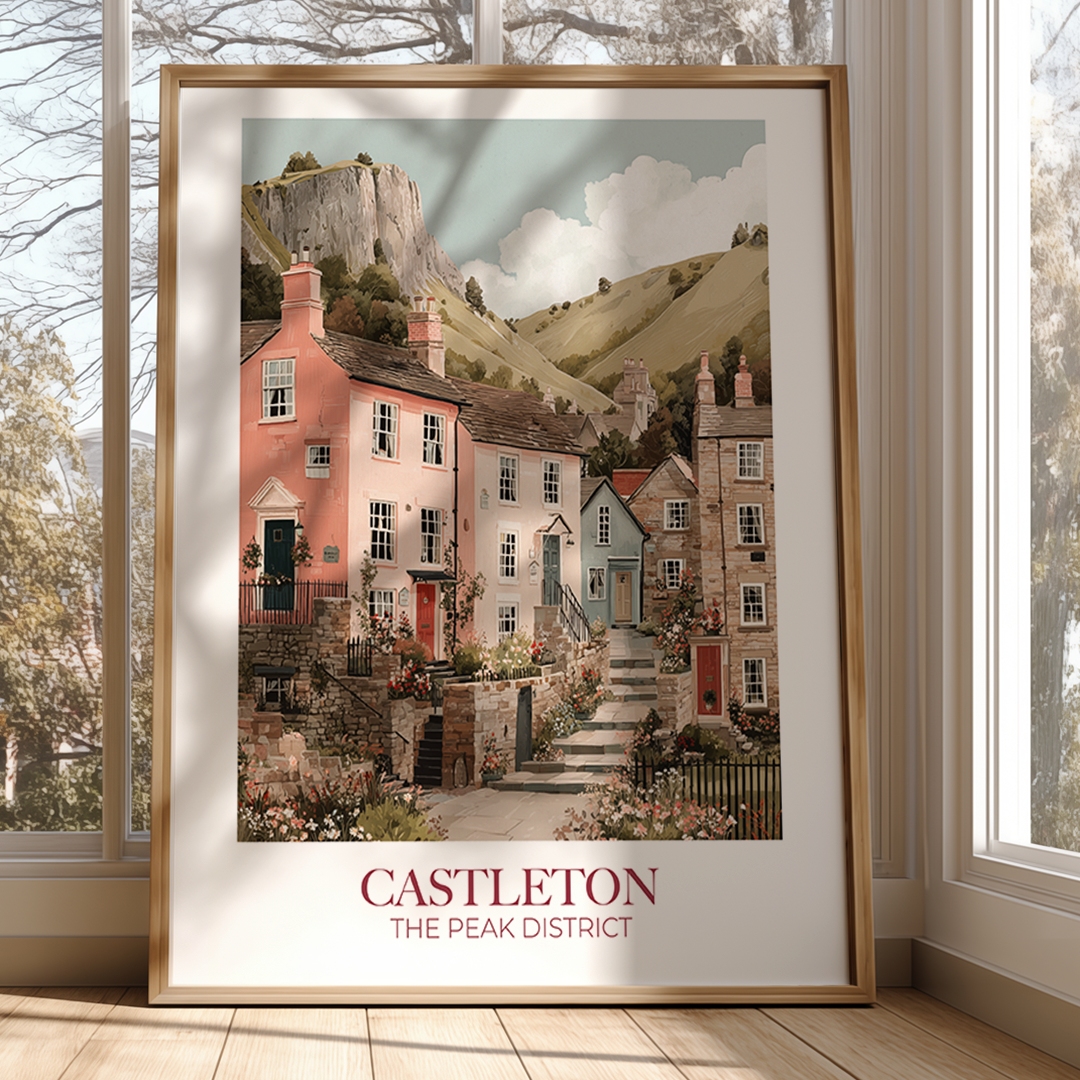 Framed artwork of a village scene with 'Castleton' and 'The Peak District' text, displayed in a room with windows.
