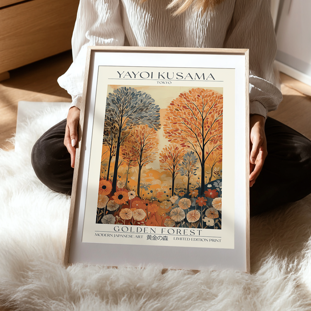 Framed Yayoi Kusama 'Golden Forest' print held by a person on a soft surface.
