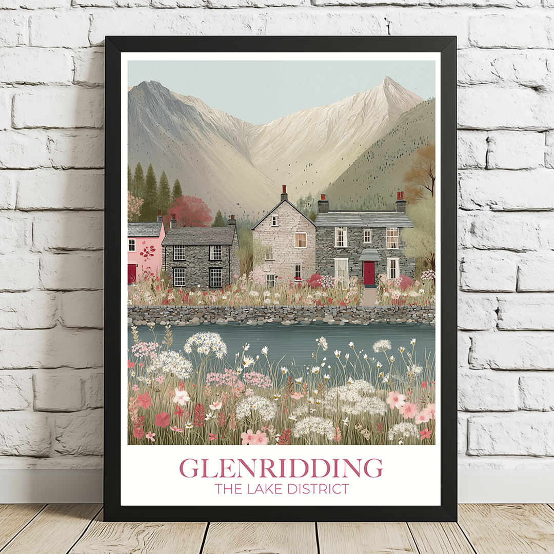 Framed artwork of Glenridding in The Lake District with houses and mountains on a white brick wall.