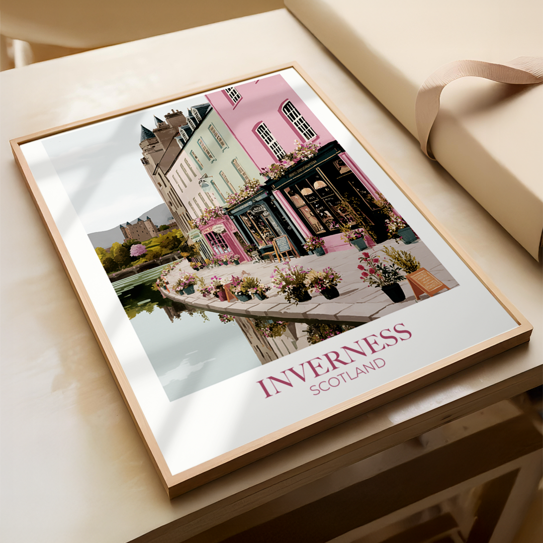Framed print of a scenic view with 'Inverness, Scotland' text on a wooden surface.