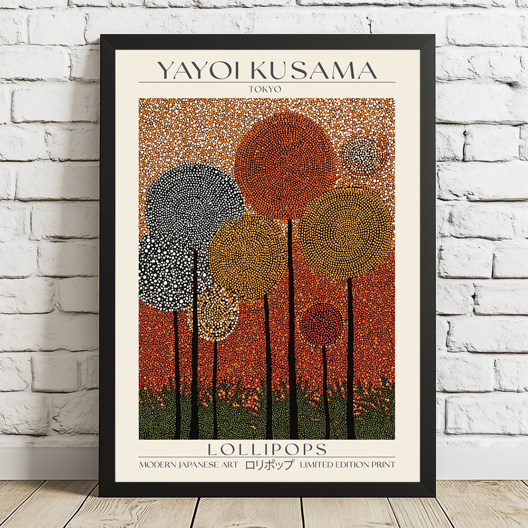 Framed Yayoi Kusama art print of lollipops on a white brick wall.