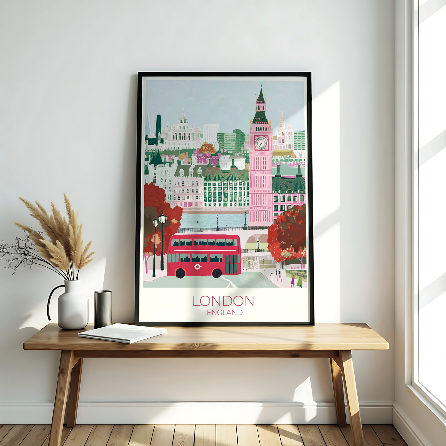 Framed artwork of London with a red bus and Big Ben on a wooden bench.