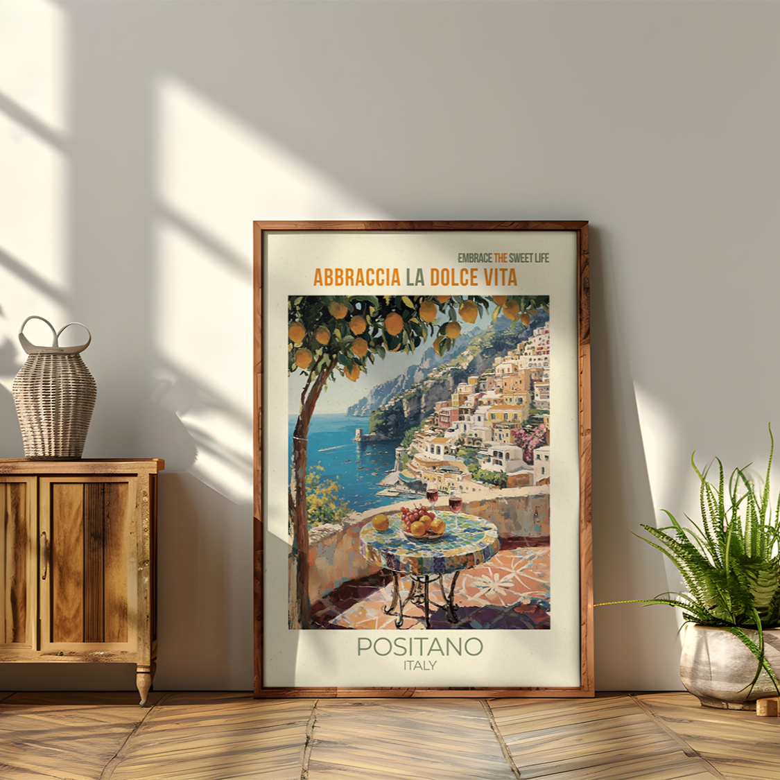 Framed poster of Positano with a wooden cabinet and plants in a room.