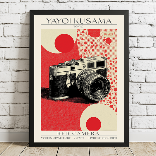 Framed poster of a camera with red and beige design on a white brick wall.