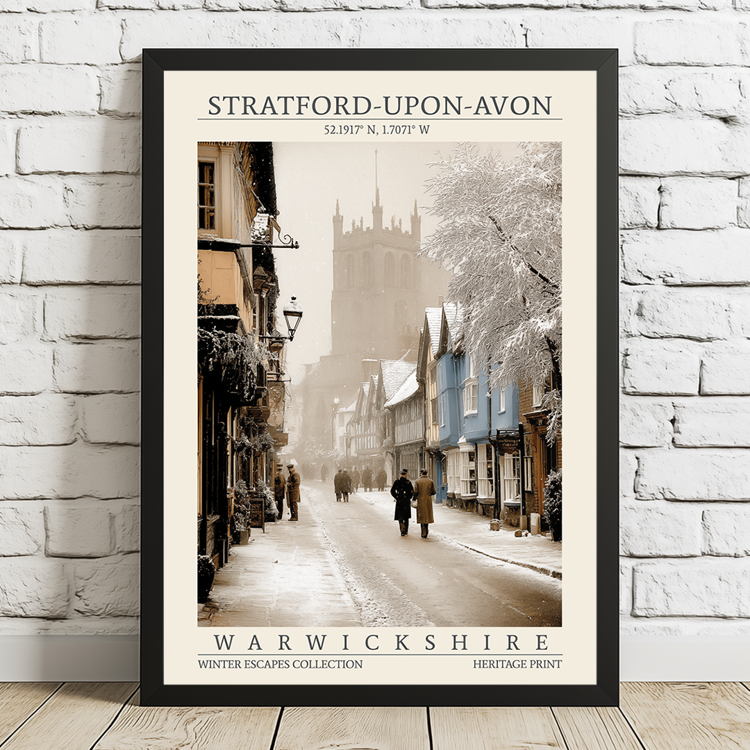 Framed poster of a snowy street scene in Stratford-upon-Avon, Warwickshire, on a white brick wall.