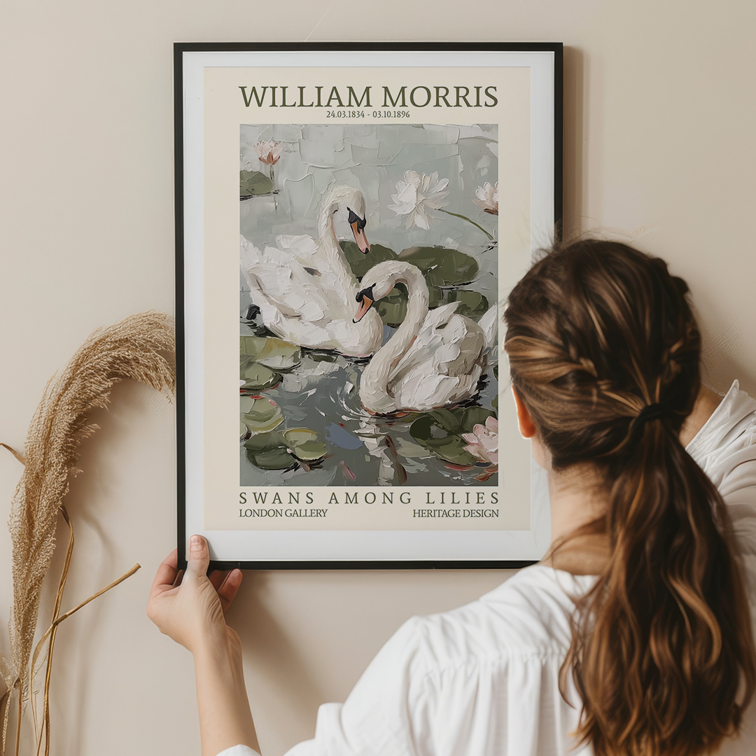 Woman holding a framed poster of swans among lilies by William Morris.