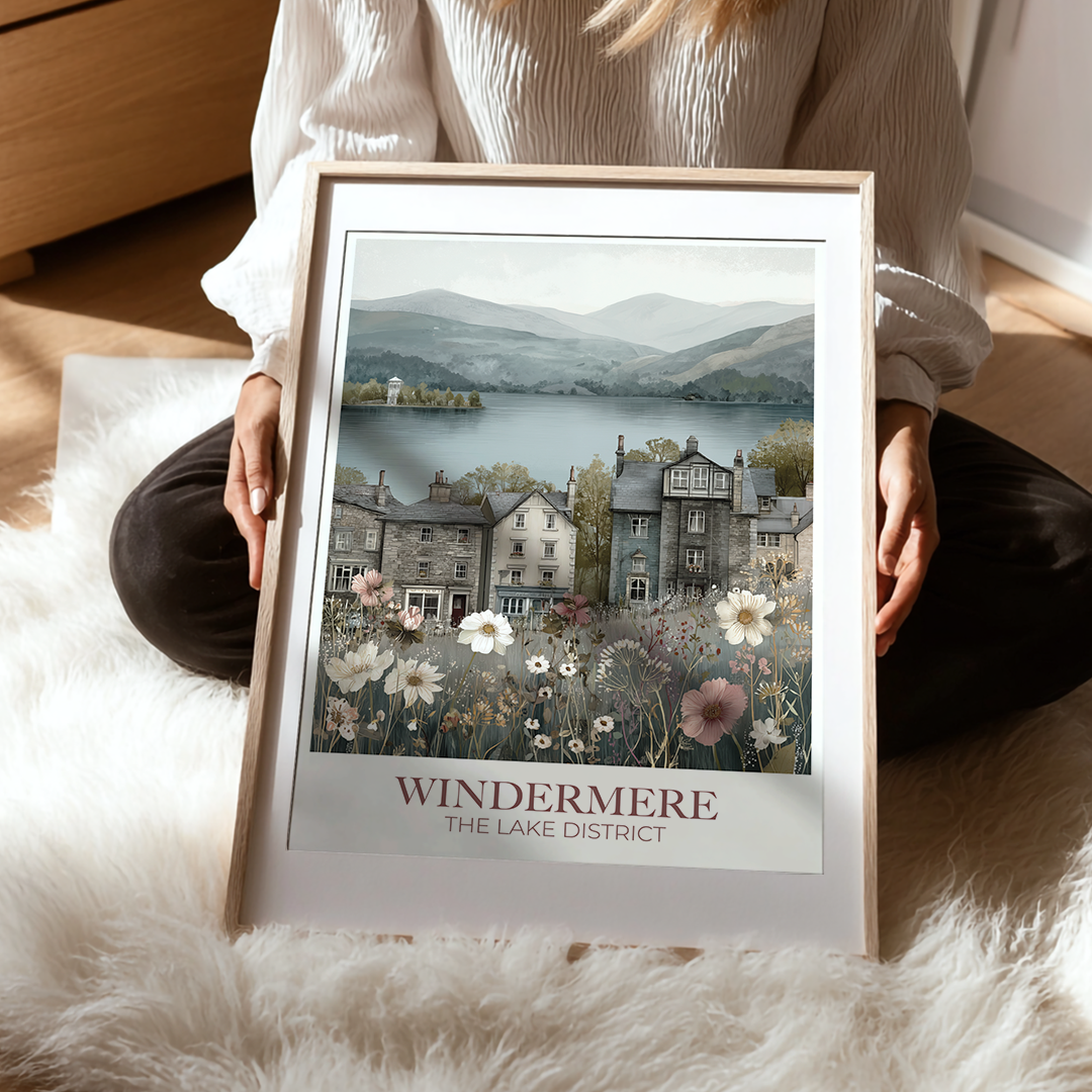 Person holding a framed print of Windermere, The Lake District with a scenic view and flowers.