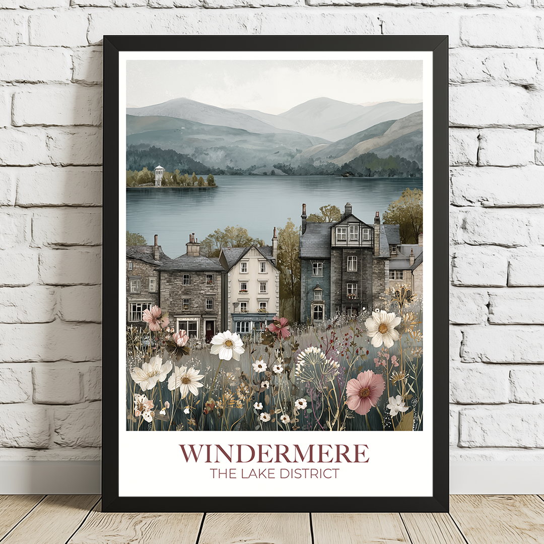 Framed artwork of a scenic view with houses and mountains, featuring the text 'Windermere The Lake District'.